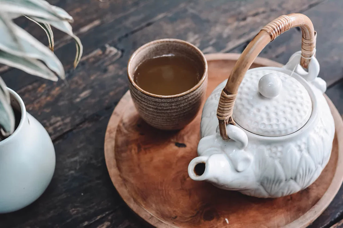 Tetera con taza de mate cocido sobre la mesa