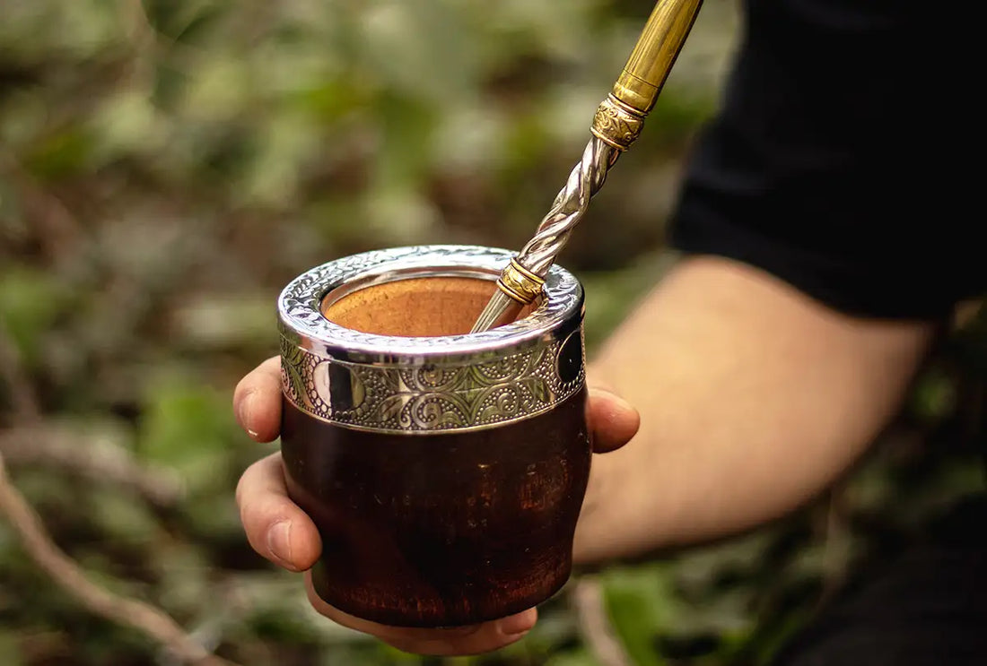 Persona sosteniendo mate imperial de madera con bombilla de alpaca