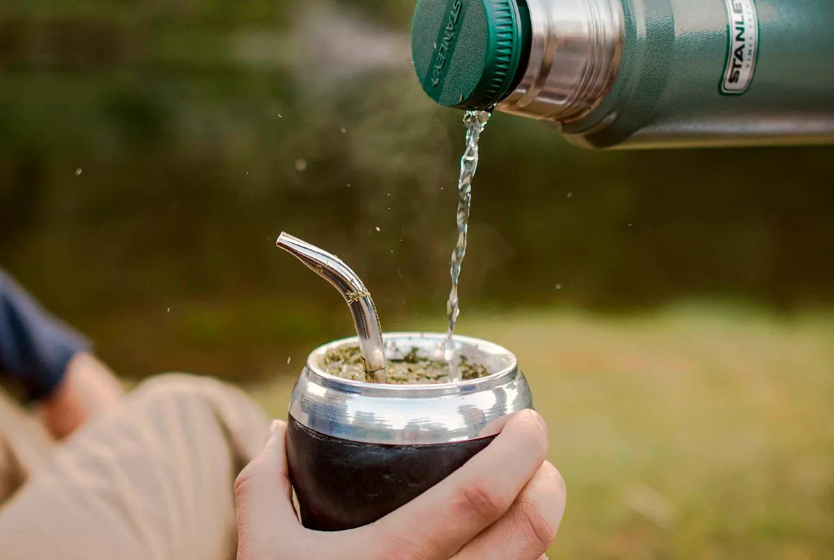 Persona cebando un mate con termo durante la jornada de trabajo