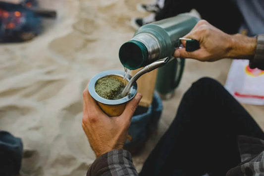 Persona cebando mate con termo de agua