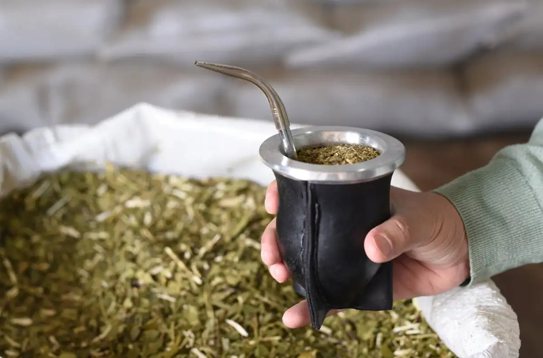 Persona sosteniendo un mate de calabaza forrado en cuero