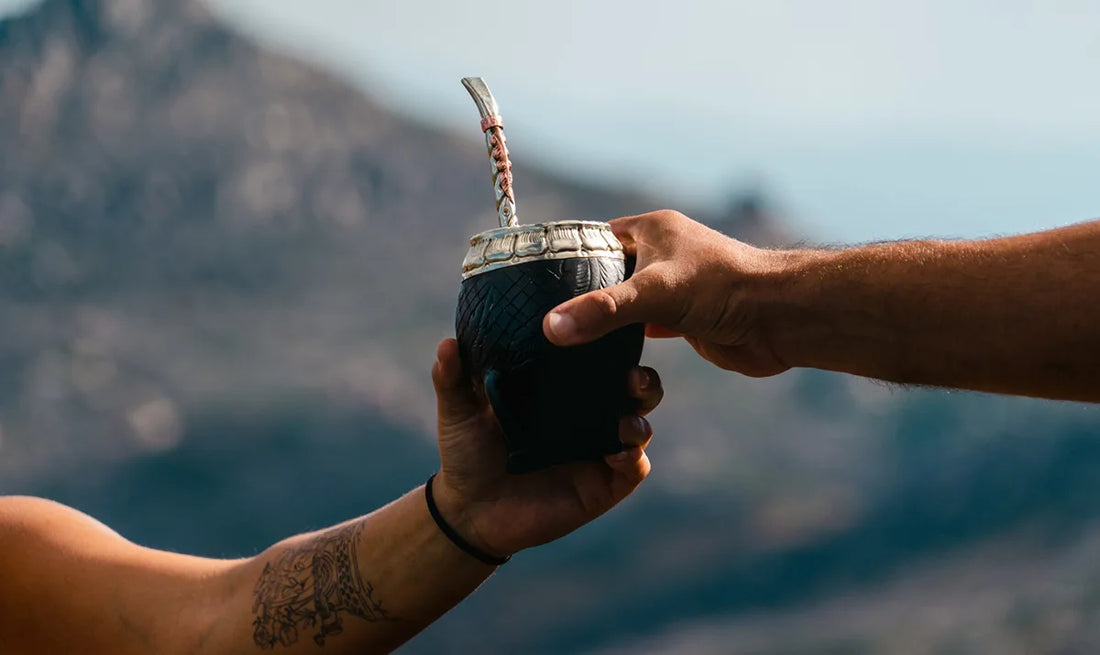 Dos personas compartiendo un mate de calabaza