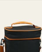Boldo Bolso Matero in black with orange trim, featuring a sturdy top handle and adjustable shoulder strap.