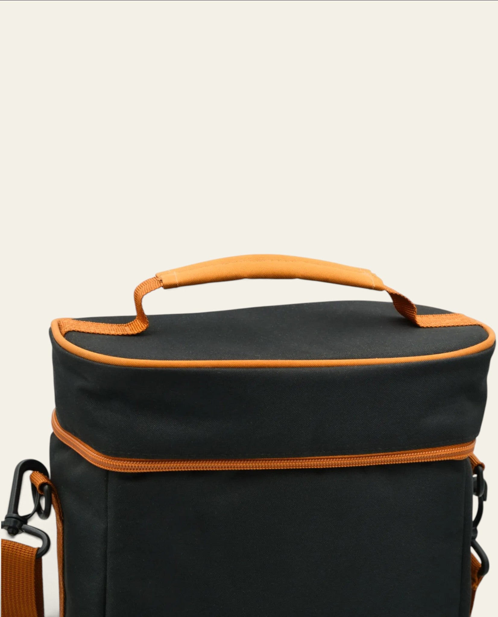 Boldo Bolso Matero in black with orange trim, featuring a sturdy top handle and adjustable shoulder strap.